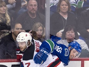 Alex Biega fights for control of the puck with Devils defenceman Jon Merrill.