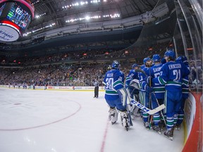 Vancouver Canucks' Henrik Sedin, back right, of Sweden, is mobbed by his teammates who came off the bench to congratulate him after scoring a goal against the Florida Panthers to record his 1,000th career point, during the second period of an NHL hockey game in Vancouver, B.C., on Friday January 20, 2017.
