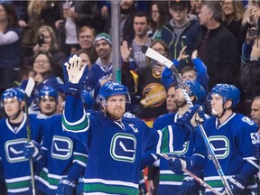 Captain Henrik Sedin of the Vancouver Canucks waves to the crowd as he receives a standing ovation at Rogers Arena after scoring a goal against the visiting Florida Panthers on Friday to record his 1,000th National Hockey League point