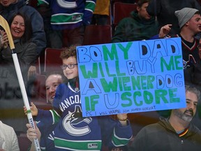 Adley Hefter hoists his sign and a stick signed by Bo Horvat near the end of Wednesday night's Canucks game.