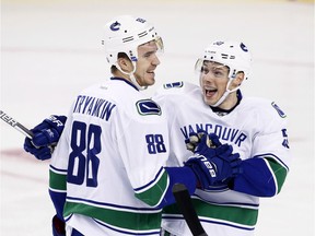 Vancouver Canucks defenceman Nikita Tryamkin, left, celebrates his goal against Calgary last month with Brendan Gaunce. Both of Tryamkin's NHL goals have come against the Flames, including one last season.