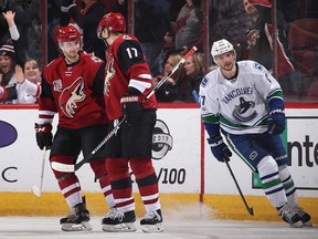 Tobias Rieder celebrates an empty-net goal with Radim Vrbata as Sven Baertschi looks ahead to the all-star break.