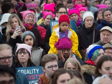 A young girl sits on the shoulders of a man during a women's march and protest against U.S. President Donald Trump, in Vancouver, B.C., on Saturday January 21, 2017.