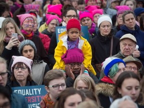 A young girl sits on the shoulders of a man during a women's march and protest against U.S. President Donald Trump in Vancouver on Jan. 21. Protests were held across Canada in support of the Women's March on Washington, D.C.