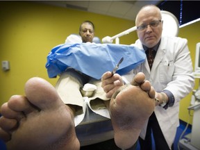 Podiatrist Scott Schumacher in his Surrey office in January 2017 examines patient Rakesh Rajguru, who has had two toes amputated, but believes the rest of his foot has been saved by Schumacher regularly cleaning the wounds after surgery so that it healed correctly. There is a  growing number of people with diabetes who have foot issues. (Mark van Manen/PNG FILES)