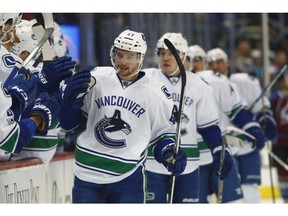 Sven Baertschi is congratulated after scoring one of two goals. against the Colorado Avalanche in the first period of an NHL hockey game Wednesday, Jan. 25, 2017, in Denver.