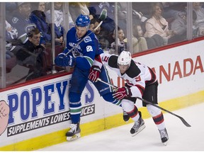 Nikita Tryamkin battles Taylor Hall along the boards.