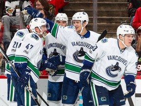 The Vancouver Canucks celebrate, including Sven Baertschi #47, Luca Sbisa #5 and Bo Horvat #53, after Horvat scored against the Chicago Blackhawks in the third period at the United Center on January 22 in Chicago, Illinois.