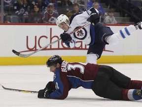 Winnipeg Jets right wing Patrik Laine, back, of Finland, follows through with his shot past Colorado Avalanche defenseman Francois Beauchemin who dives on to the ice in the second period of an NHL hockey game Saturday, Feb. 4, 2017, in Denver. The Jets will be dealing with distractions as they embark on a four-game road trip that has the potential to make or break their season.THE CANADIAN PRESS/AP/David Zalubowski