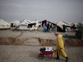 A worker carried aid supplied at a camp for people displaced by fighting between security forces and Islamic State militants east of Mosul, Iraq, Wednesday, Feb. 15, 2017. The United Nations says they are temporarily pausing aid operations to neighborhoods in eastern Mosul retaken from the Islamic State group for security reasons as IS insurgent and counter attacks continue to inflict heavy civilian casualties there.(AP Photo/Bram Janssen)