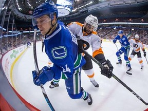 Vancouver Canucks&#039; Reid Boucher, front, is checked by Philadelphia Flyers&#039; Pierre-Edouard Bellemare, of France, during the second period of an NHL hockey game in Vancouver, B.C., on Sunday February 19, 2017. THE CANADIAN PRESS/Darryl Dyck