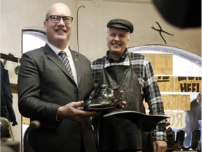 B.C. Finance Minister Mike de Jong picks up his newly soled shoes at Olde Towne Shoe Repair from owner Mike Waterman in advance of the provincial budget in Victoria on Feb. 20.