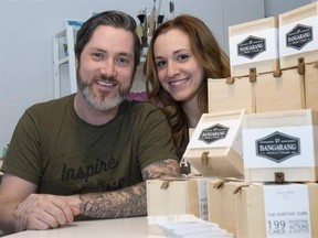 Martin Brouillard and Marie-Eve D&#039;Amico are seen next to a display of Positive Cubes, a small wooden box produced by the Quebec-based company Bangarang Friday, February 24, 2017 in Beloeil, Que. The boxes that contain 199 cards, each bearing a positive or inspirational saying, will be part of the gift bags handed out at the Oscars Sunday. THE CANADIAN PRESS/Paul Chiasson