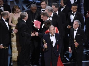 Fred Berger, foreground center, and the cast of &ampquot;La La Land&ampquot; mistakenly accept the award for best picture at the Oscars on Sunday, Feb. 26, 2017, at the Dolby Theatre in Los Angeles. The actual winner of best picture went to &ampquot;Moonlight.&ampquot; (Photo by Chris Pizzello/Invision/AP)