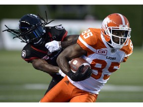 Receiver Shawn Gore of the B.C. Lions keeps the ball from Redblacks' defender Abdul Kanneh during CFL action last year in Ottawa.
