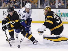 Vancouver Canucks' Brandon Sutter (20) battles Boston Bruins' Torey Krug (47) in front of goalie Anton Khudobin (35), of Kazakhstan, during the third period of an NHL hockey game in Boston, Saturday, Feb. 11, 2017. The Bruins won 4-3.