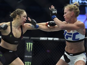 In this Nov. 15, 2015, file photo, Ronda Rousey, left, and Holly Holm battle during their UFC 193 bantamweight title bout in Melbourne, Australia.