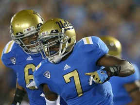 Safety Tevin McDonald of the UCLA Bruins celebrates with linebacker Eric Kendricks after his interception and  50 yard return in the third quarter against the Houston Cougars at the Rose Bowl on September 15, 2012.