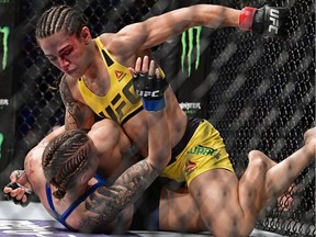 Jessica Andrade, top, punches Joanne Calderwood during a women's straw-weight bout at UFC 203 on Sept. 10, 2016, in Cleveland.
