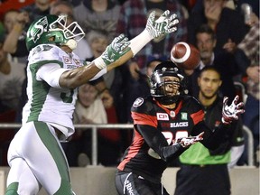 Redblacks Chris Williams catches the ball to score a touchdown as he's defended by Saskatchewan Roughriders Justin Cox during CFL action on Oct. 7, 2016, in Ottawa.