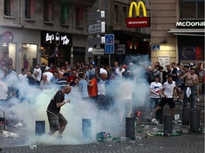 A tear gas canister explodes next to a football fan as England fans clash with police in Marseille.