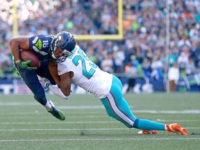 Dolphin cornerback Xavien Howard throws a tackle on Seahawk Tyler Lockett that shows technique familiar to rugby fans.