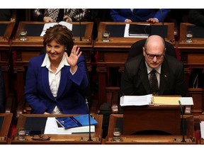 Premier Christy Clark waves to a person as B.C. Finance Minister Michael de Jong waits to deliver a balanced budget for a fifth year in a row at the legislature in Victoria, on Feb. 21.