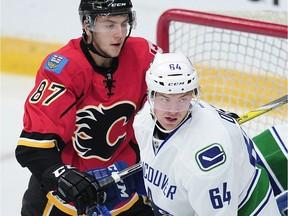 Vancouver Canucks prospect Tate Olson, right, patrols the crease in front of Calgary Flames Mathieu Sevigny during NHL Young Stars Classic action at the South Okanagan Events Centre in Penticton on Sept. 19, 2016.