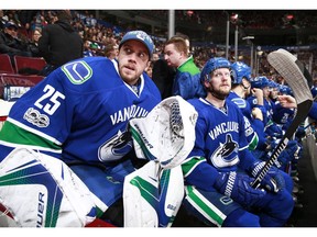 Jacob Markstrom and Alex Edler look on from the bench against the Flyers.