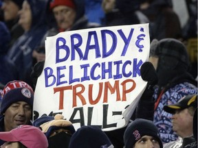 FILE - In this Sunday, Jan. 22, 2017, file photo, a New England Patriots fan holds a sign referring to Patriots quarterback Tom Brady, head coach Bill Belichick and President Donald Trump during the first half of the AFC championship NFL football game between the Patriots and the Pittsburgh Steelers in Foxborough, Mass. Brady says Trump is someone he's known for 16 years and he doesn't see why their relationship is "such a big deal." He says "if you know someone, it doesn't mean that you agree with everything they say or do."