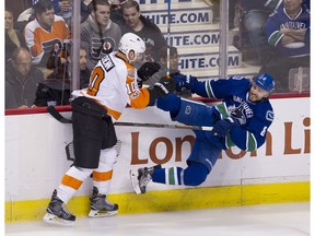 Chris Tanev gets knocked to the ice by Brayden Schenn.