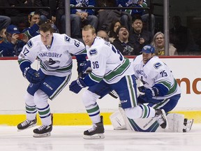 Jacob Markstrom (right) gets a free ride from Joseph LaBate and Jannik Hansen.