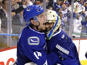 Vancouver's Alex Burrows celebrates with goalie Roberto Luongo after winning the Western Conference following the Canucks' win over the San Jose Sharks in overtime in Game 5 of the Stanley Cup playoffs at Rogers Arena on May 24, 2011.