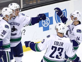 Bo Horvat celebrates with Jannik Hansen, Alex Edler and Alex Burrows after scoring against the Bruins on Saturday.