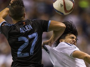 Whitecaps FC Mauro Rosales is grabbed by New York FC RJ Allen in an MLS game in Vancouver on Sept. 26, 2015.