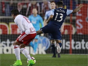 Vancouver Whitecaps midfielder Cristian Techera (13) kicks New York Red Bulls midfielder Salvatore Zizzo (15) during the second half of a CONCACAF Champions League quarterfinal soccer match, Wednesday, Feb. 22, 2017, in Harrison, N.J. Techera was ejected from the game because of the hard kick on Zizzo.