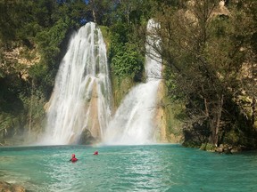 Swimmers relax in turquoise water below one of many waterfalls in the Huasteca region after  rappelling down the cliff beside it.