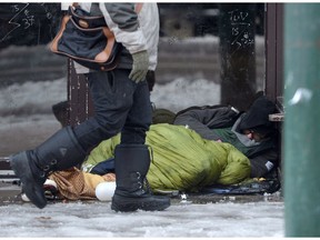 A homeless man sleeps in a doorway in Vancouver's Downtown Eastside in December 2016.