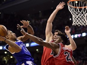 Toronto Raptors guard DeMar DeRozan (10) drives to the net to set up teammate Toronto Raptors forward Patrick Patterson (54) as Chicago Bulls forward Jimmy Butler (21) and Chicago Bulls forward Paul Zipser (16) defend during overtime NBA basketball action, in Toronto on Tuesday, March 21, 2017. THE CANADIAN PRESS/Frank Gunn