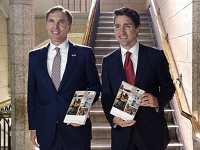 Federal Finance Minister Bill Morneau, left, and Prime Minister Justin Trudeau display the 2017 federal budget document.