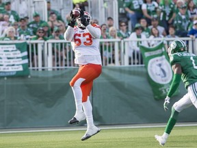 B.C. Lions' all-star tackle Jovan Olafioye catches a touchdown pass against the Saskatchewan Roughriders last July. The Lions, facing salary cap issues, dealt him east.