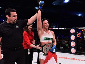 Julia Budd stands triumphant in the center of the cage after defeating Marloes Coenen to become the inaugural Bellator women's featherweight champion.
