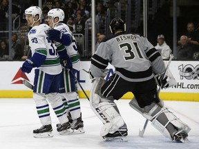 Los Angeles Kings goalie Ben Bishop watches as Vancouver Canucks Henrik Sedin and Bo Horvat celebrate Sedin's goal during the first period of Saturday's game in Los Angeles.