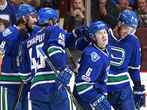 Brock Boeser of the Canucks is congratulated by teammates Brandon Sutter, Christopher Tanev and Michael Chaput after scoring a goal.