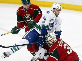 Vancouver Canucks' Brandon Sutter collides with Minnesota Wild goalie Darcy Kuemper, right, during the first period of Saturday's game in St. Paul, Minn.