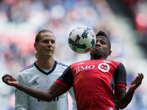 Toronto FC midfielder Armando Cooper, right, knocks the ball down in front of Vancouver Whitecaps midfielder Brek Shea during the first half of an MLS soccer game in Vancouver, B.C., on Saturday March 18, 2017.