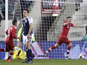 Fraser Aird, right, celebrates scoring Canada's first goal of the game against at Easter Road in Edinburgh on Wednesday.
