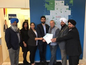 Community Minister Peter Fassbender hands out $75,000 in government cheques to the Surrey Newton Rotary Club at his B.C. Liberal campaign office on March 18.