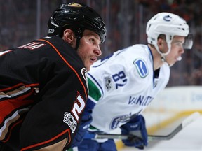 Kevin Bieksa and Nikolay Goldobin line up for a face-off.