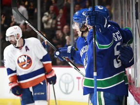 Troy Stecher is congratulated by Markus Granlund after scoring to tie the game against the Islanders.